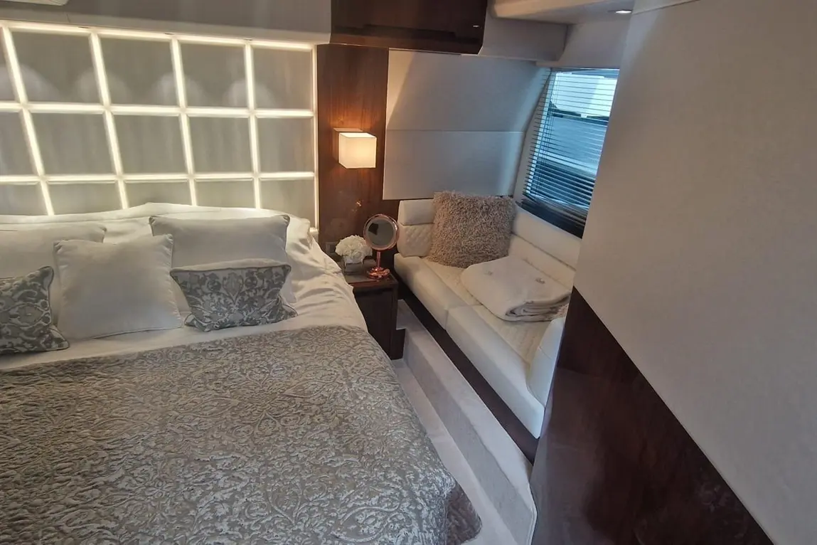 Luxurious bedroom featuring a king-size bed, plush pillows, and a stylish seating area with soft cushions and a sleek lamp.